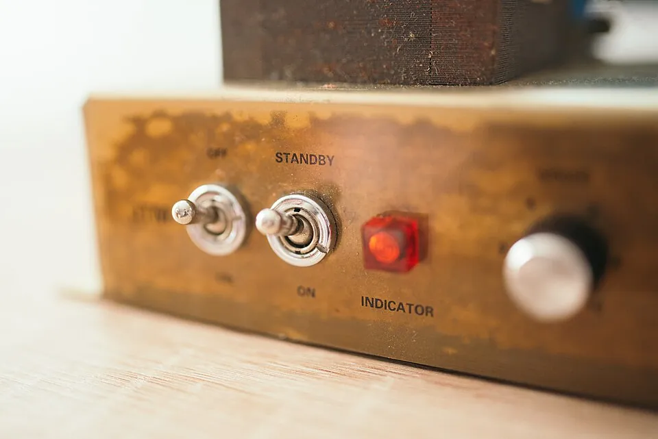 Close-up view of a vintage device's control panel featuring toggle switches labeled on and standby, alongside a red indicator light, showcas
