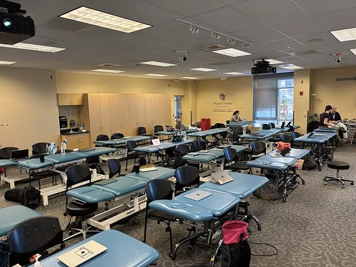 This image shows the Physical Therapy classroom at the University of Colorado Anschutz in 2025. The room contains multiple treatment tables,
